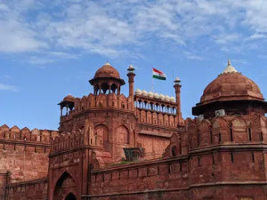 A photograph capturing the Indian flag fluttering proudly at the Red Fort in Delhi, also known as Lal Quila.